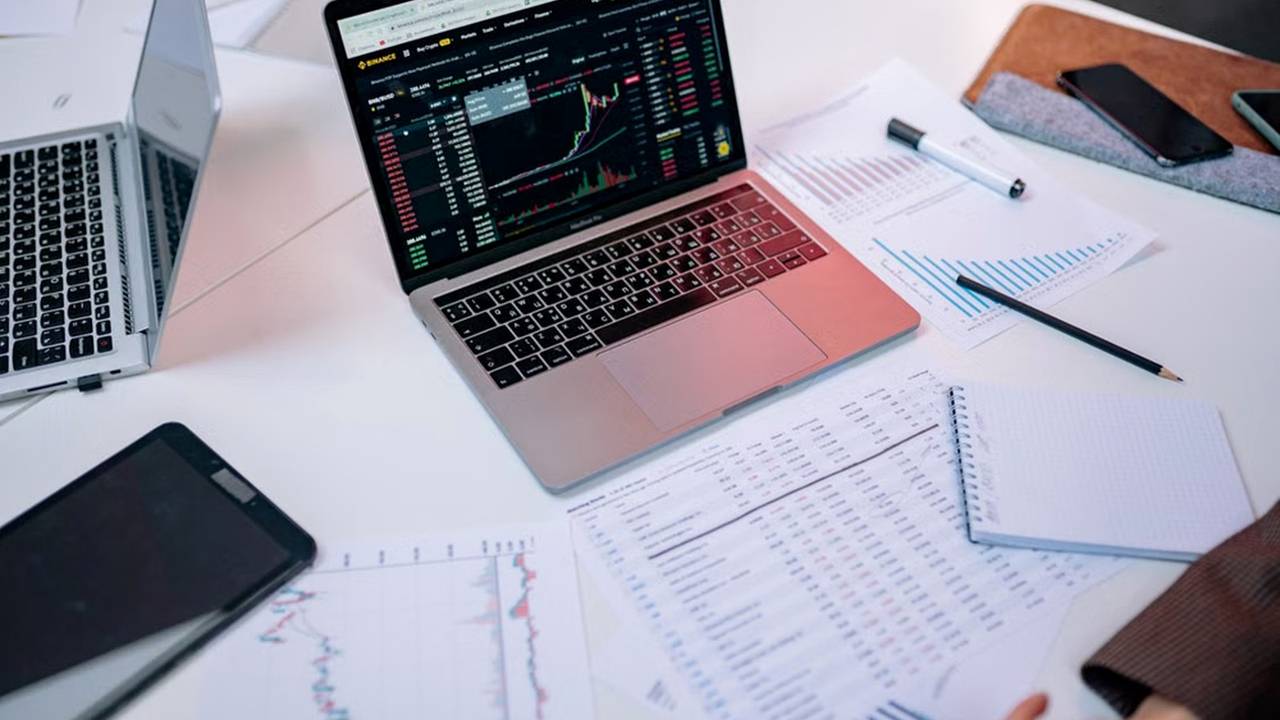 Laptop hiển thị dashboard tài chính và các bảng biểu phân tích khi đọc file feasibility study bất động sản